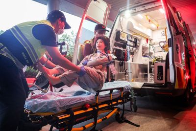 Medical staff carry a mock patient into an ambulance