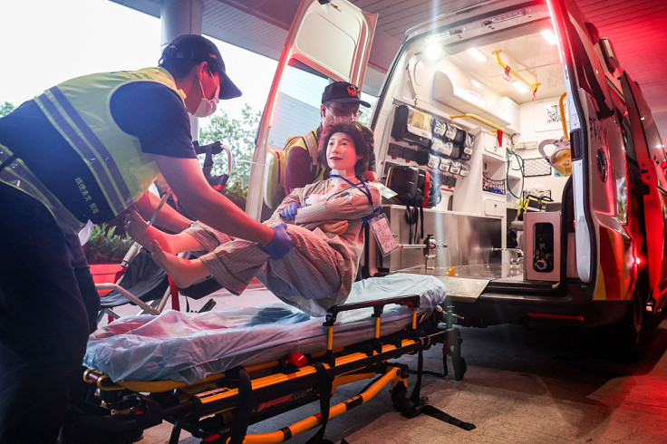 Medical staff carry a mock patient into an ambulance