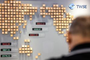 A man walks past a board showing numbers